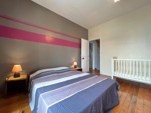 a bedroom with a bed and a striped wall at Le Roadtrip- Maison - Jardin - Tramway - 8p in Le Mans