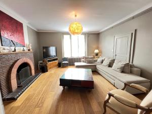 uma sala de estar com um sofá e uma lareira em Le Roadtrip- Maison - Jardin - Tramway - 8p em Le Mans