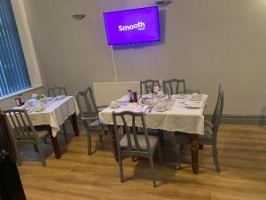 un comedor con mesas y sillas y una pantalla púrpura en Bradburys of Blackpool, en Blackpool