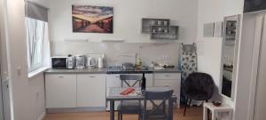 a kitchen with white cabinets and a table in it at Studio Apartman Tariba in Rab