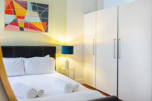 a bedroom with a bed and a white cabinet at Dynamic in Dean Street in London