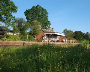 a house in the middle of a field with flowers at Rowden Mill Station in Bromyard