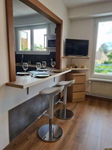 a kitchen with two bar stools and wine glasses at Studio cosy et lumineux bike parking in Saverne