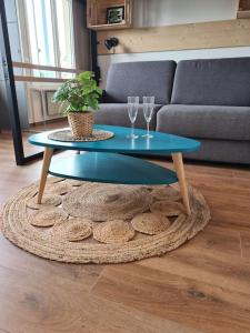a blue coffee table with two wine glasses on a rug at Studio cosy et lumineux bike parking in Saverne