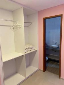 a room with white shelves and a bathroom with a sink at CasAMAR lençóis in Santo Amaro