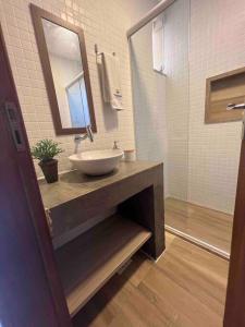 a bathroom with a sink and a mirror and a shower at CasAMAR lençóis in Santo Amaro