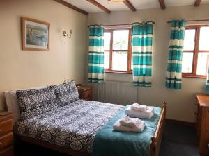 a bedroom with a bed with towels on it at Deanwood Holiday Cottages in Yorkley