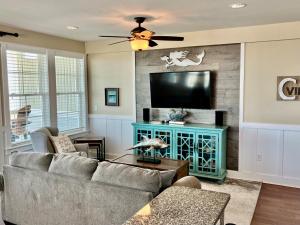 a living room with a couch and a flat screen tv at SC302 - C-View in Kill Devil Hills