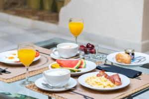 ヘレス・デ・ラ・フロンテーラにあるホテル YIT カーサ グランデの朝食用の食材トレイ、オレンジジュース2杯