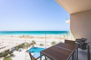 a balcony with a table and a view of the beach at Voyage 5 Star Mamsha With Ocean Views in Abu Dhabi