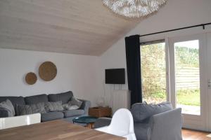 ein Wohnzimmer mit einem Sofa und einem Tisch in der Unterkunft Essenereng in Kootwijkerbroek