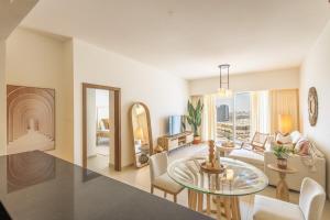 soggiorno con tavolo in vetro e soggiorno di Voyage One Bedroom In Reem Island a Abu Dhabi