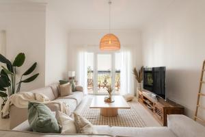 sala de estar con sofá y TV en Voyage Ansam Three Bedroom With Ocean Views en Abu Dabi