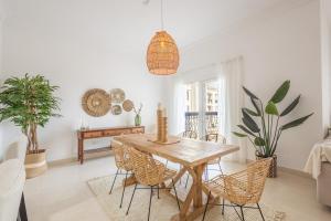 uma sala de jantar com uma mesa de madeira e cadeiras em Voyage Ansam Three Bedroom With Ocean Views em Abu Dhabi