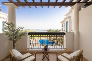 uma varanda com cadeiras e vista para o oceano em Voyage Ansam Three Bedroom With Ocean Views em Abu Dhabi