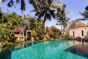 een zwembad voor een huis met palmbomen bij Sukanami Villa Ubud by ecommerceloka in Gianyar
