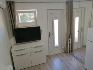 a living room with a flat screen tv on a cabinet at Apartment Mara in Primošten