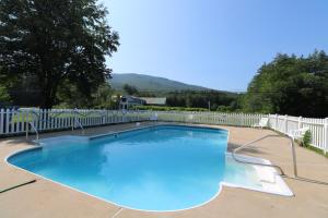 a swimming pool in a yard with a white fence at The Villager Motel in Bartlett