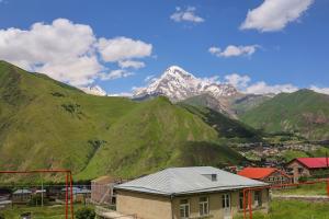 a view of a mountain range with a house at Heaven Hill in Kazbegi