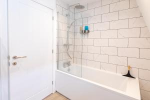 y baño blanco con ducha y bañera. en Dawson House- gorgeous two bedroom with free parking, en Southampton