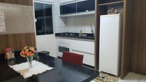 a kitchen with a vase of flowers on a table at Apartamento Inteiro in Blumenau