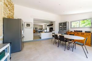 a kitchen with a table and chairs and a refrigerator at La Procureuse in Barjols