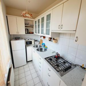 a kitchen with white cabinets and a white refrigerator at Blaško apartment in Izola