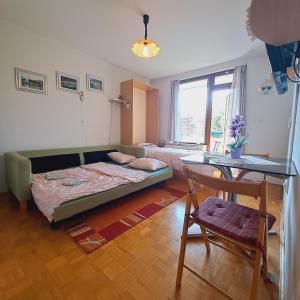 a bedroom with a couch and a table and a chair at Blaško apartment in Izola