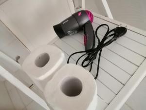 a hair dryer and a blow dryer next to a toilet at Una Stanza a Cefalù in Cefalù