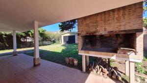 an outdoor fireplace with a brick wall on a patio at Casa Rustica in Villa Carlos Paz