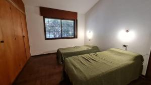 Pokój z 2 łóżkami i oknem w obiekcie Casa Rustica w mieście Villa Carlos Paz