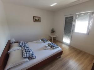ein Schlafzimmer mit einem Bett mit zwei Kissen und einem Fenster in der Unterkunft Guest house with pool Ante in Vrsi