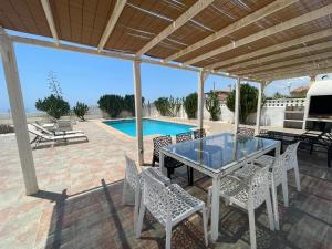 米哈斯的住宿－Villa turística Sol y Mar，一个带桌椅的庭院和一个游泳池