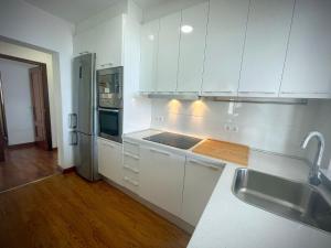 a kitchen with white cabinets and a stainless steel refrigerator at Villa turística Sol y Mar in Mijas