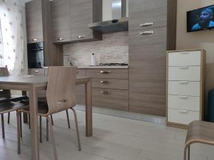 uma cozinha com armários de madeira e uma mesa com cadeiras em La Torre em Maiori