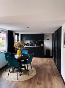 una cucina e una sala da pranzo con tavolo e sedie di Het Blij Hoen a Oudenbosch