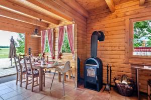 comedor con estufa de leña en una cabaña de madera en Ferienblockhaus Glocker - Hof, en Leibertingen