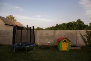 a childs play house and a trampoline in a yard at Vila Lio & Restaurant Devojacki Bunar in Novi Vladimirovac