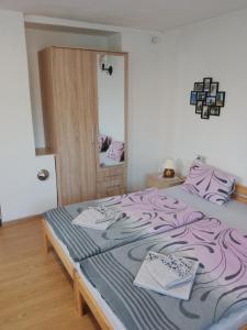 um quarto com uma cama com lençóis roxos e um espelho em apartman.lara em Děčín