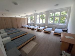 Márianosztrai Zarándokszálláshely في Márianosztra: غرفة كبيرة بها صفوف من الكراسي والنوافذ