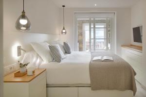 Un dormitorio blanco con una cama grande y una mesa en Port Luxe by FeelFree Rentals, en Naut Aran (Alto Arán)