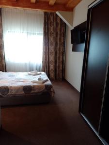 a bedroom with a bed and a window at Cabana Bella Vista in Ranca