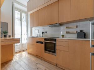 a kitchen with wooden cabinets and a stove top oven at The Best Rent - Spacious apartment near Colonne S Lorenzo in Milan