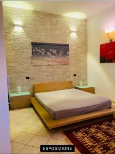 una camera da letto con un letto e un dipinto sul muro di Casa Ridente: Porto Cesareo Centro a Porto Cesareo