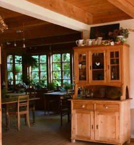 a kitchen with wooden cabinets and a dining room at Siedlisko Klangor in Wiżajny