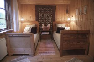 1 dormitorio con 2 camas en una habitación con paredes de madera en Siedlisko Klangor en Wiżajny