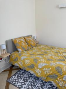 a bedroom with a bed with a yellow blanket and a rug at Domaine de Croix en Sologne in Neuvy-sur-Barangeon