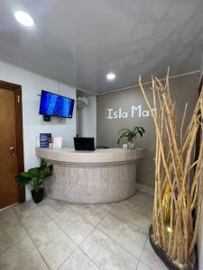 a lobby with a reception desk with a tv on the wall at Hostal islamar in San Andrés