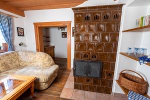 a living room with a couch and a fireplace at Penzion pod Pralesem in Velké Karlovice