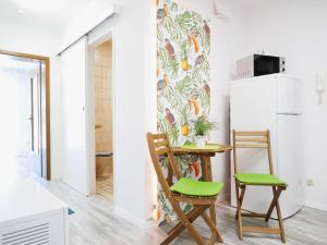 a kitchen with a table and two chairs and a refrigerator at Ferienwohnung mit Garten in Ehrenkirchen